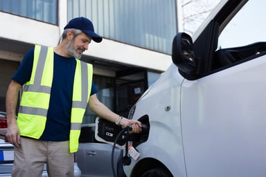 worker charges an electric vehicle.