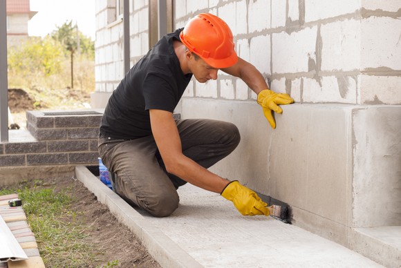 A worker smooths concrete at a job site.