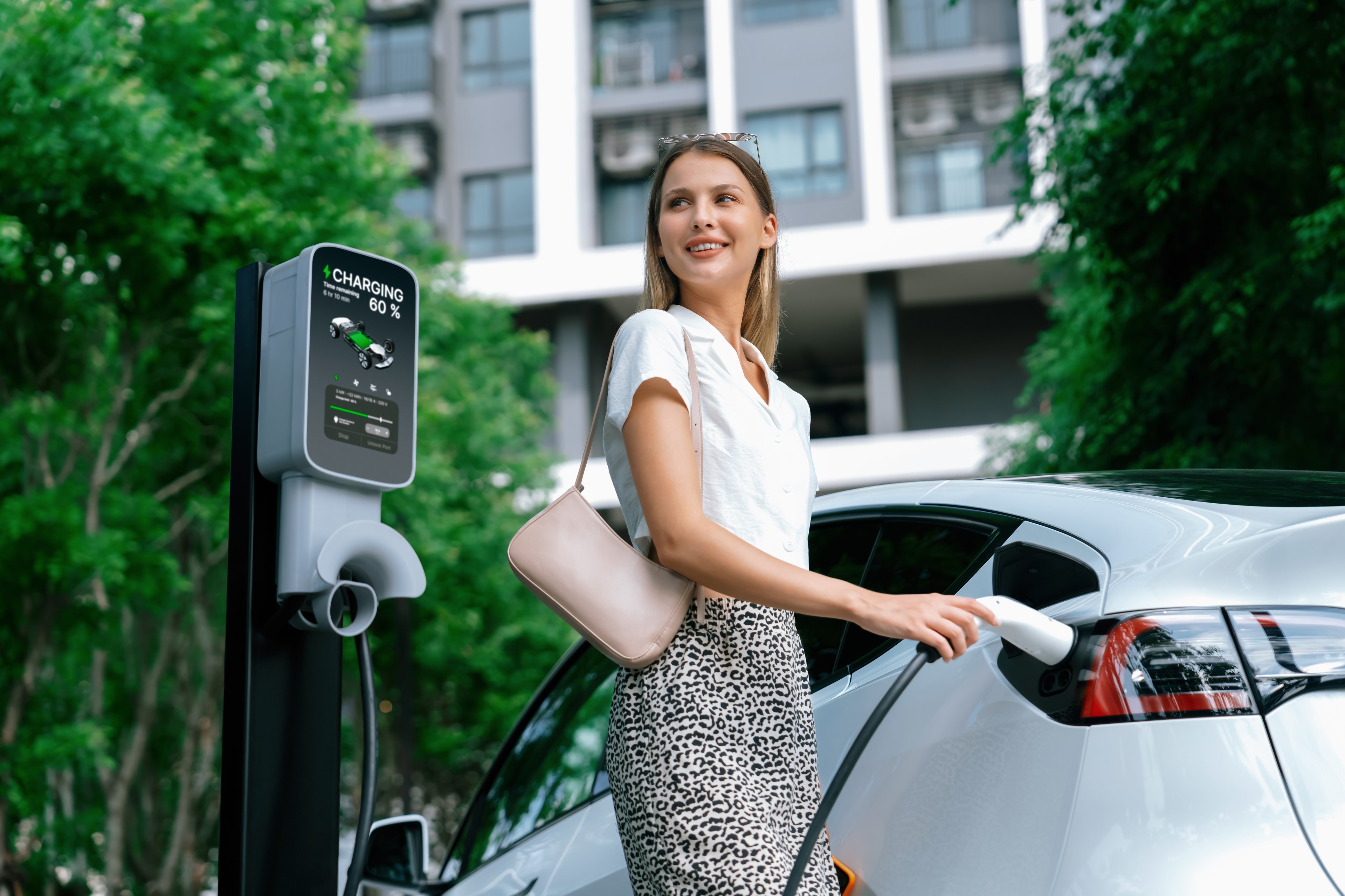 Woman charging an electric vehicle. 