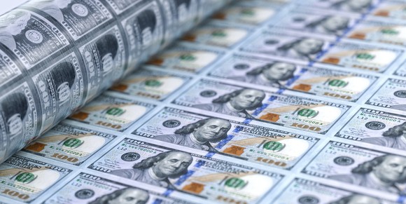 A press printing $100 bills.