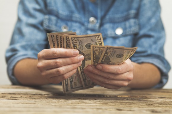 Man counting money at a table.