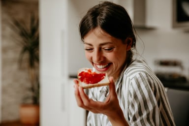 Woman eating bread with jam.