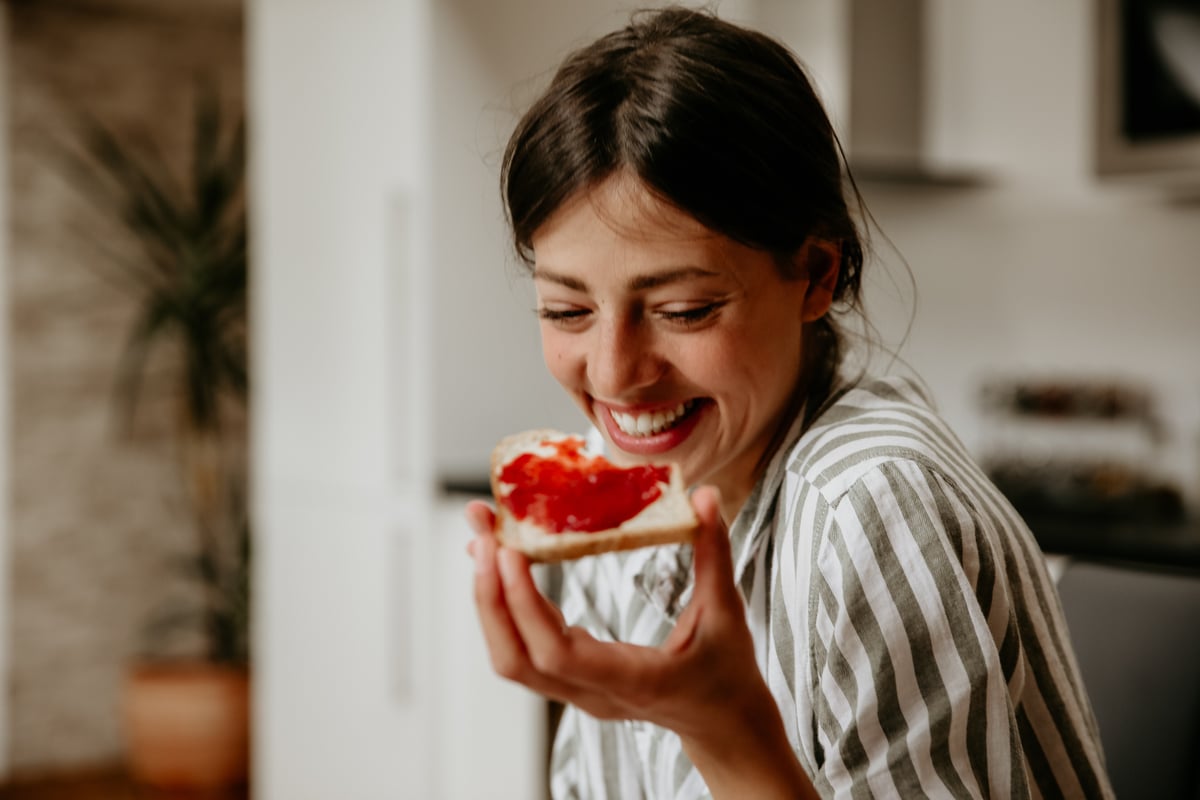Woman eating bread with jam.