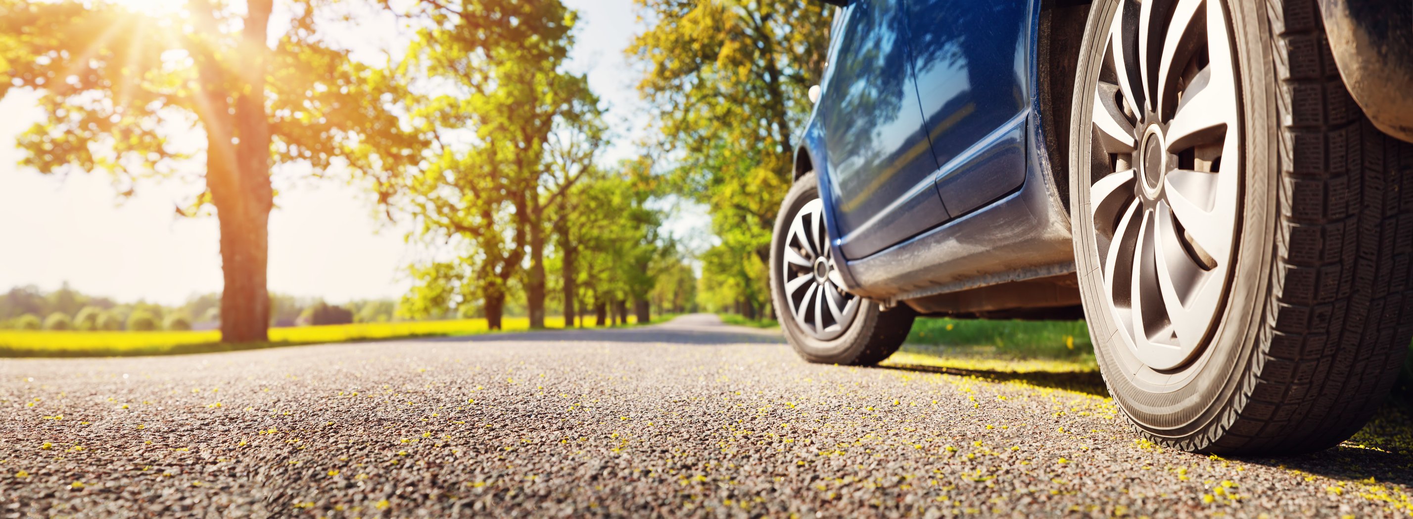 Car on road, with picture focused on wheels.