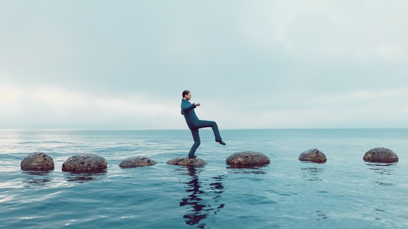 Person walks on stones across an ocean.