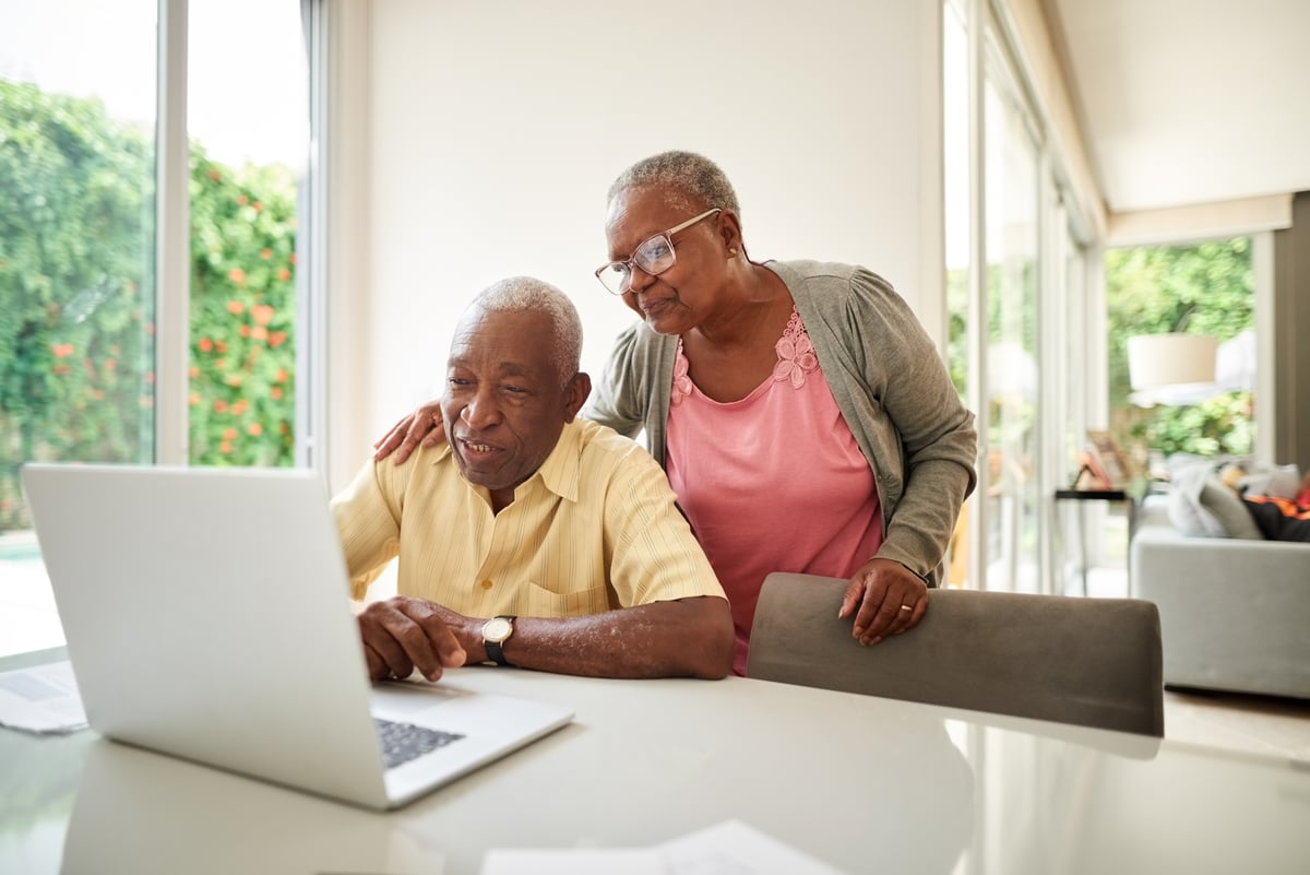 two people in a house looking at a computer