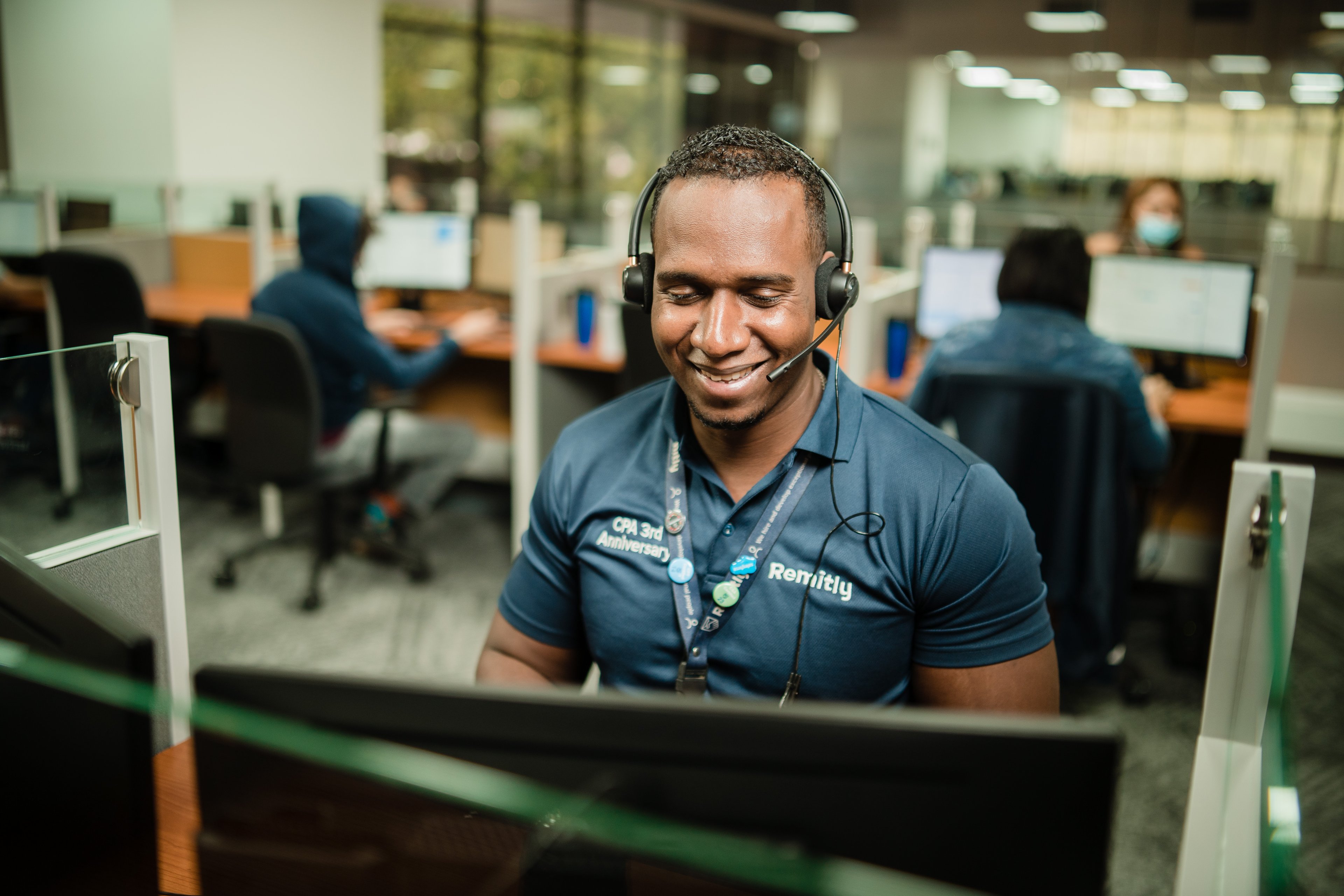 A Remitly customer service agent in front of a computer.