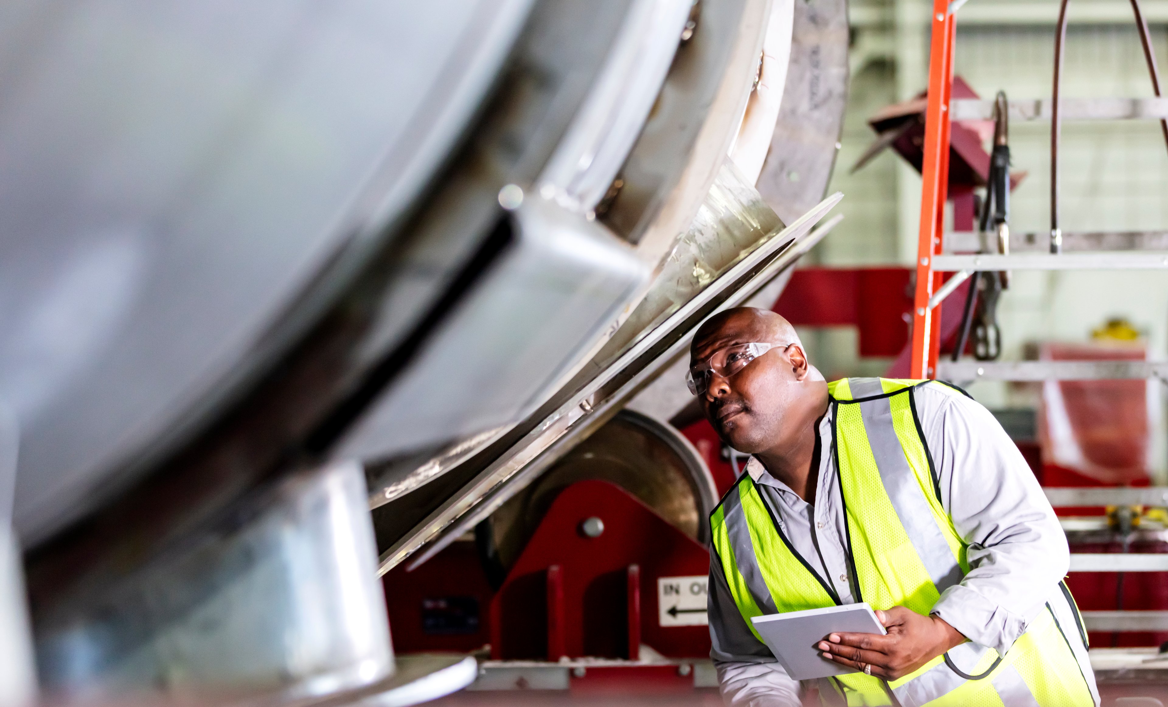 A worker inspecting machines at a steel fabrication shop. 