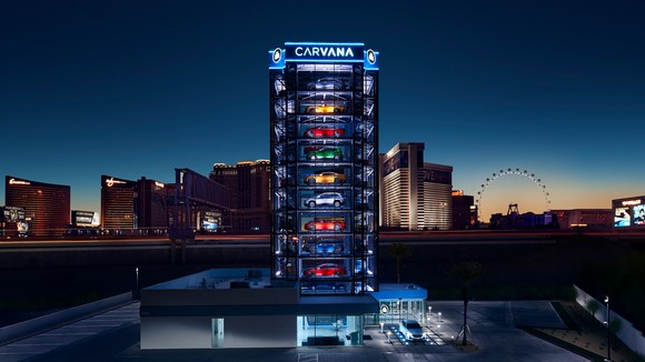 A Carvana car vending machine seen against a night skyline.