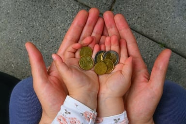 Adult and child hands holding coins