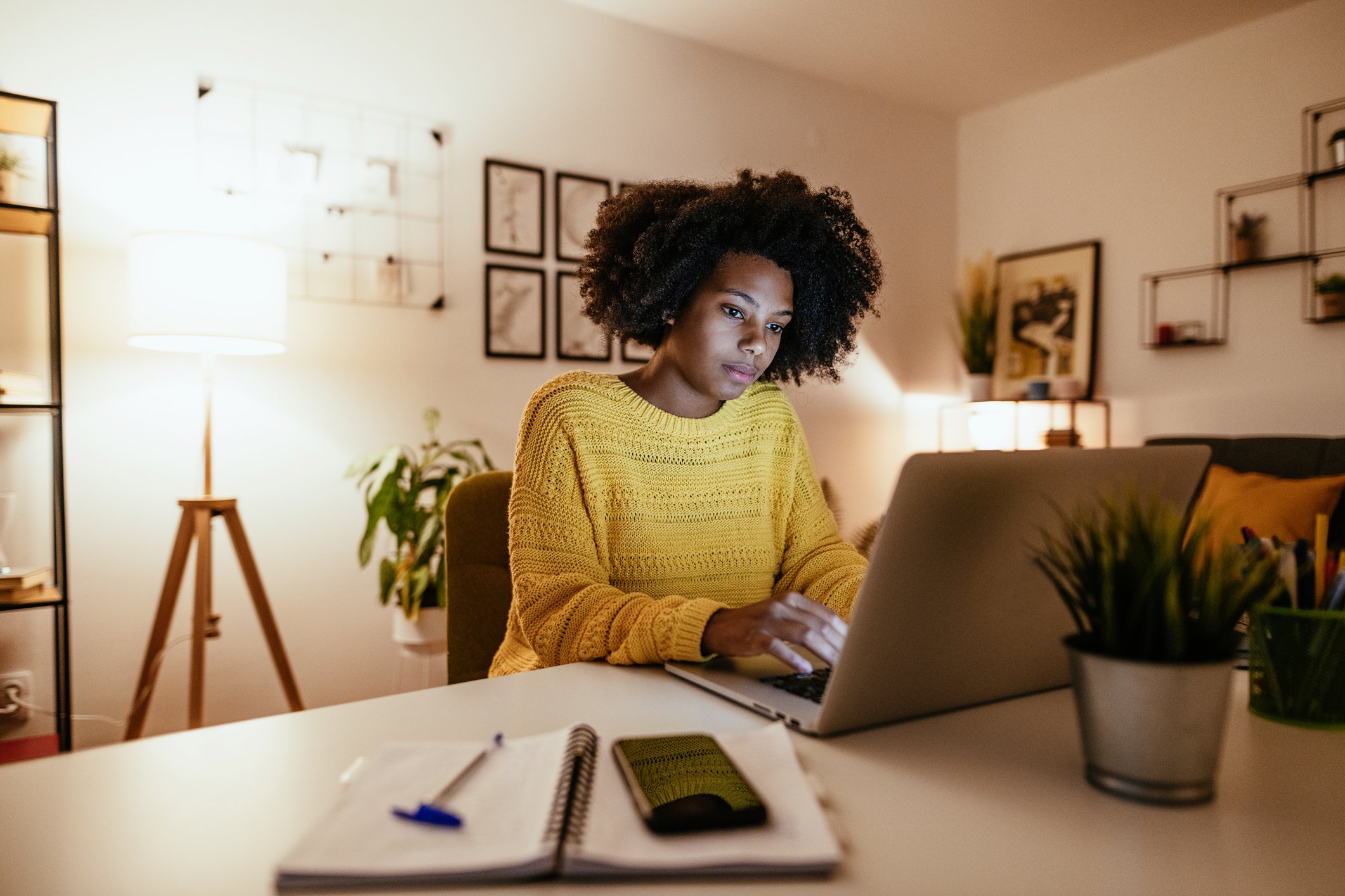 A person works on a laptop in a home office.