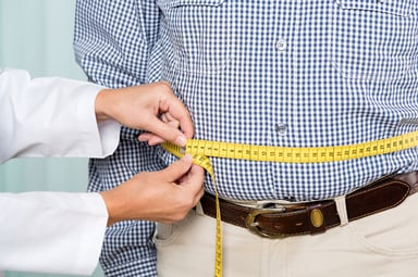Someone measuring a person's waist.