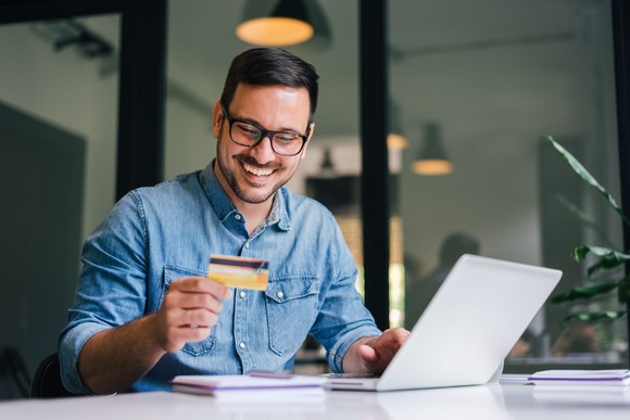 Man smiling at credit card.