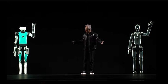 Nvidia CEO Jensen Huang on stage with images of humanoid robots on each side of him.