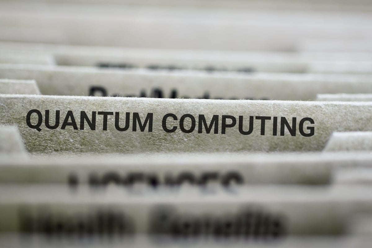 The words "quantum computing" are written on a folder in a filing system.