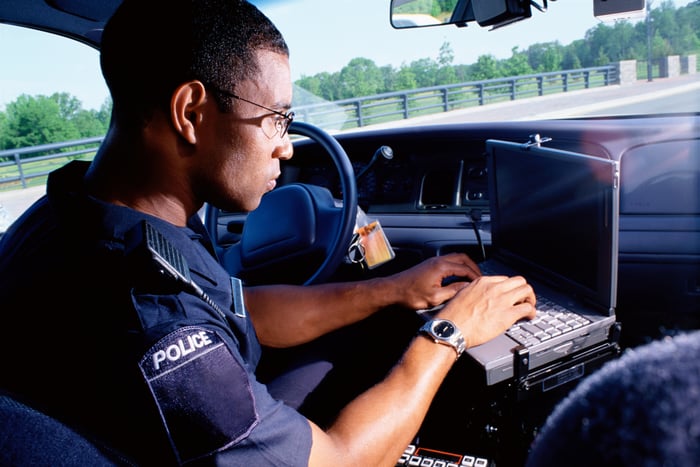 Police officer with a laptop computer.