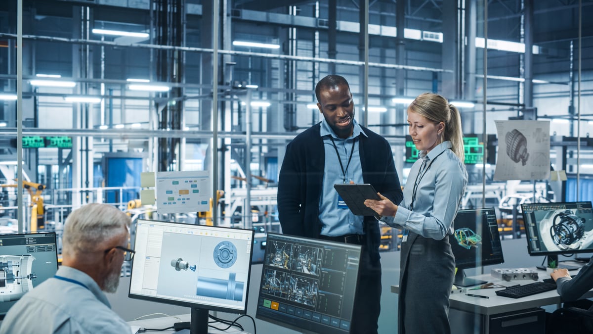 People looking at computers in a tech factory.