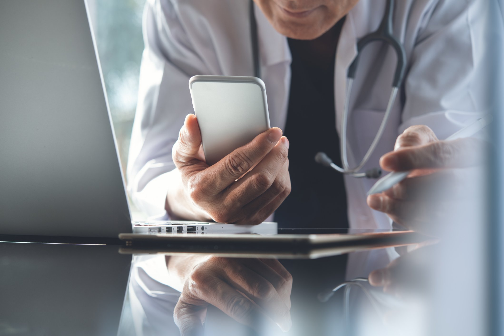 doctor working on laptop and smartphone