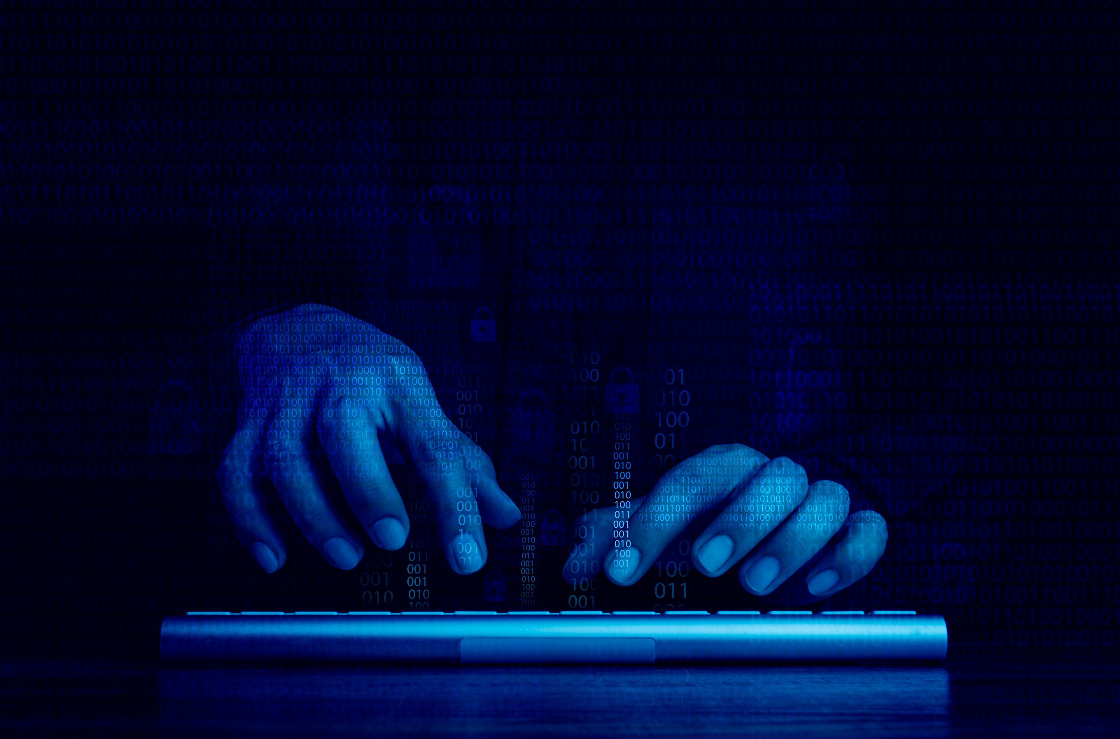 Two hands on a keyboard depicting a cyberattack