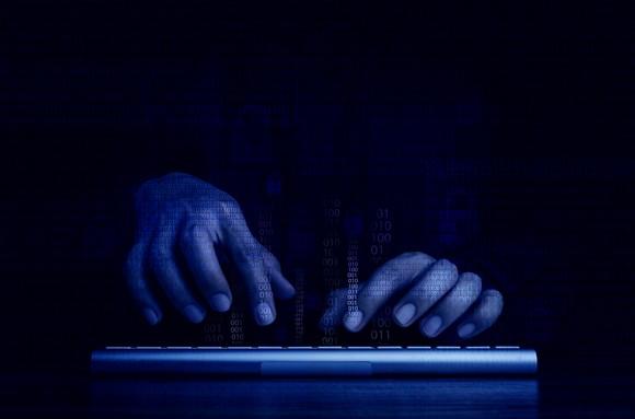 Two hands on a keyboard depicting a cyberattack