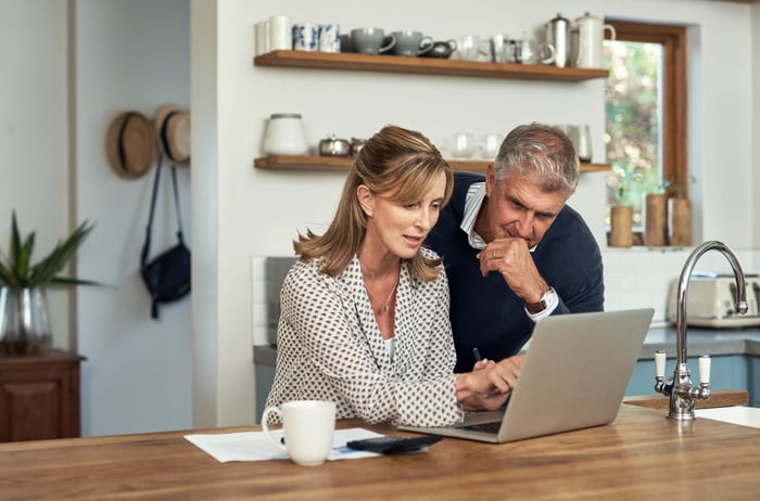 A couple looking at a computer screen.