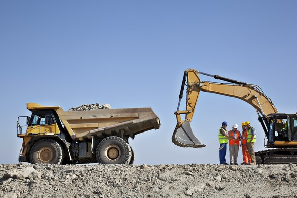 Workers working with heavy machinery on a construction site. 