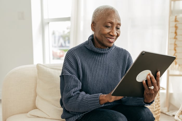 Person using a large tablet device for a telehealth appointment.