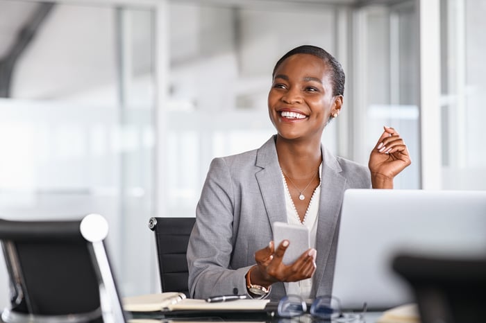 Person holding a smartphone and smiling.