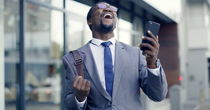 Person looking at their phone cheering.