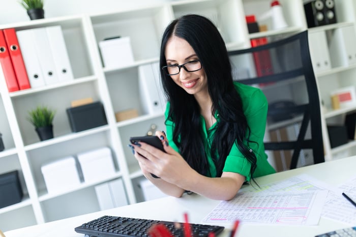 Person on phone sitting at a desk. 