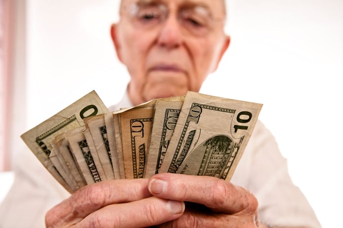 Person holding several 10 dollar bills.