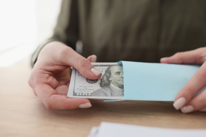 Someone holding a $100 bill.