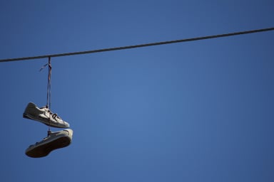 Shoes hanging from a telephone wire.