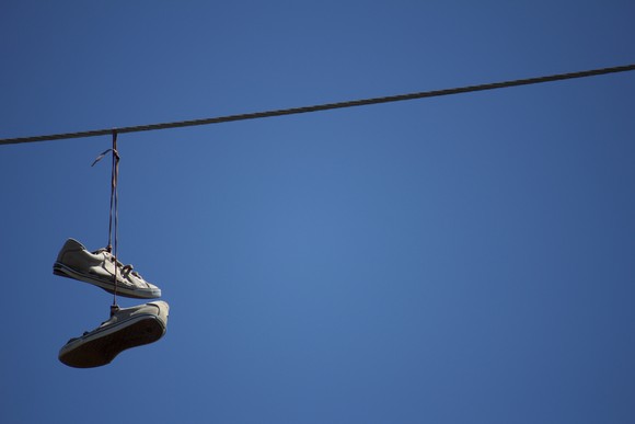 Shoes hanging from a telephone wire.