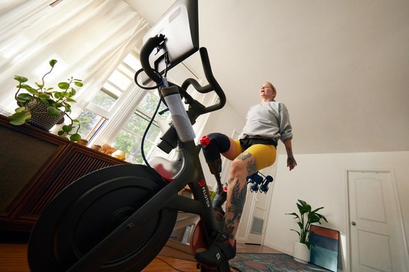 Person at home riding a Peloton bike.