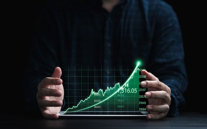 A person holding a stock chart that's moving up.