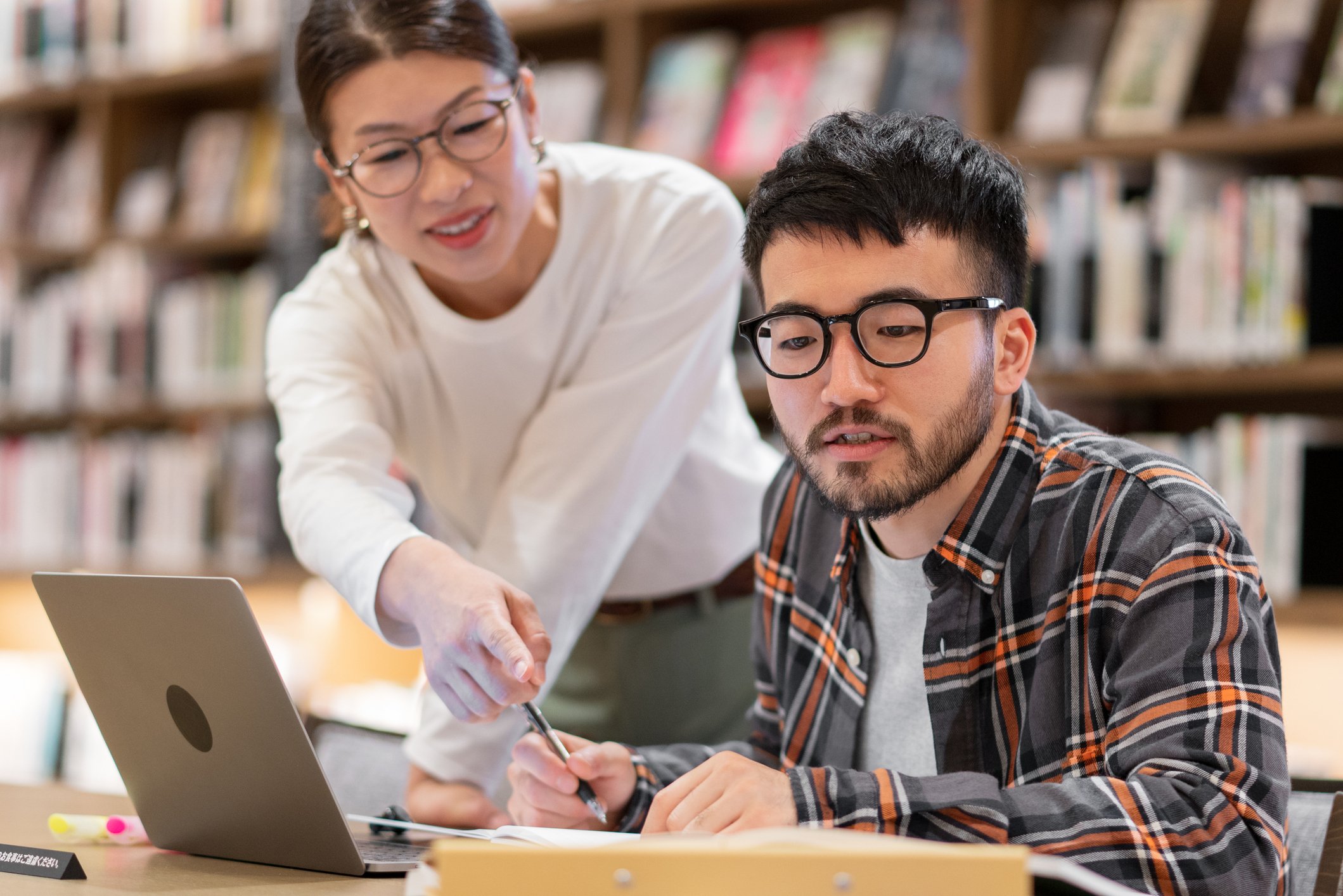 Professor talking to a student in a library (1)