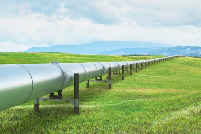 A pipeline stretches over green grass.