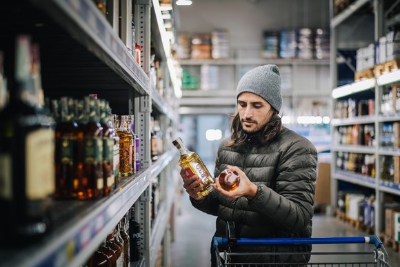 A person shopping for whiskey in a store