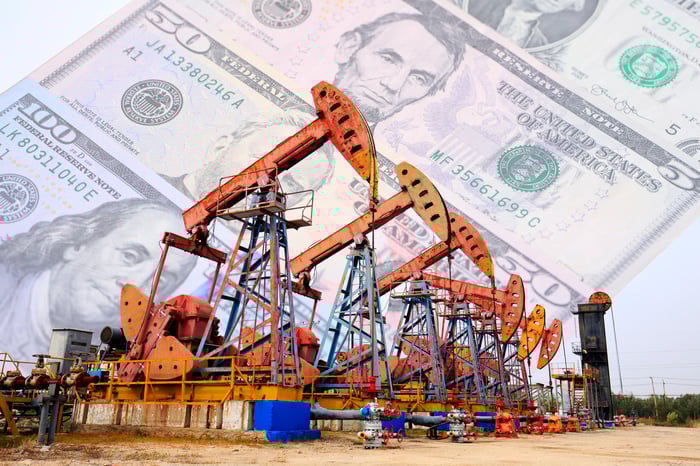 Oil pumps with money in the background. 