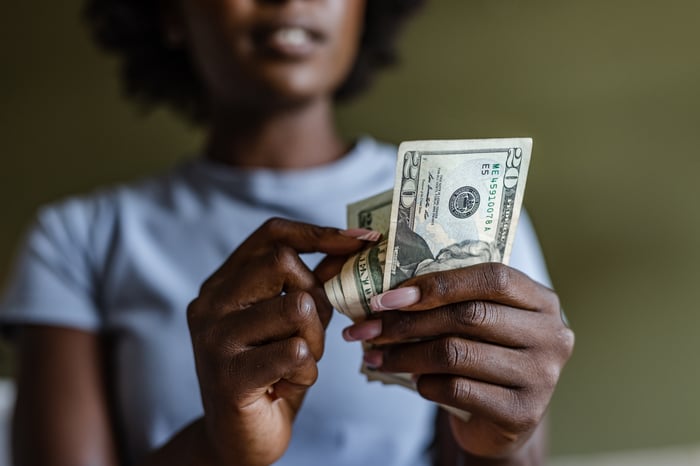 Someone holding $20 bills.