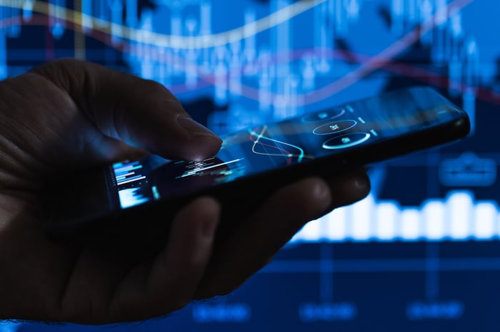Man checking his crypto portfolio on his phone. 