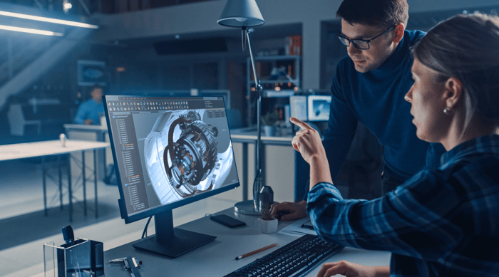 Software developers working on a 3D model on a computer.
