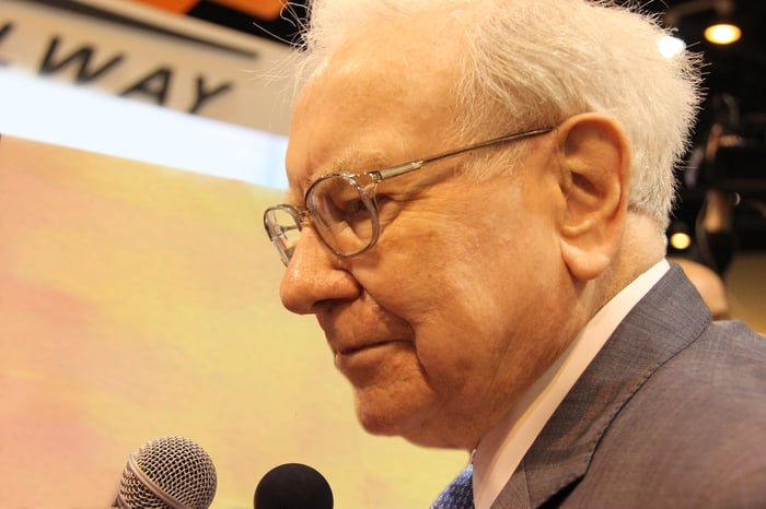 A close-up of Warren Buffett in front of a microphone.