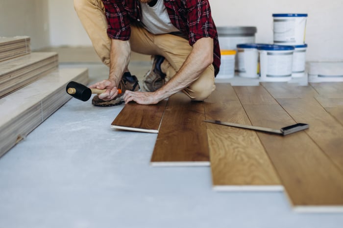 Person installing flooring in a home. 