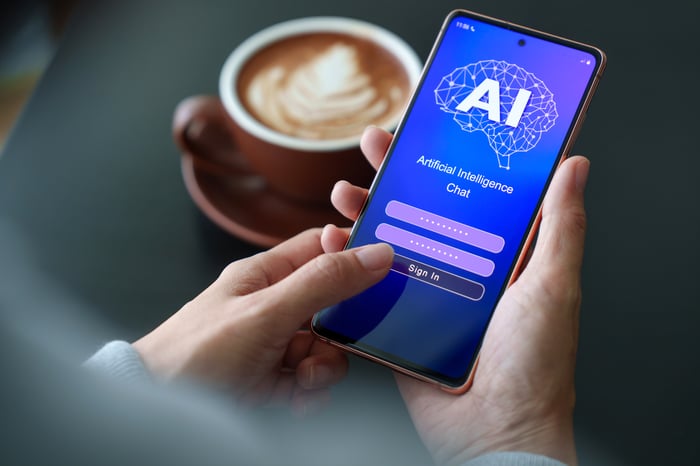 Person holding a smartphone with an AI chat application on screen.