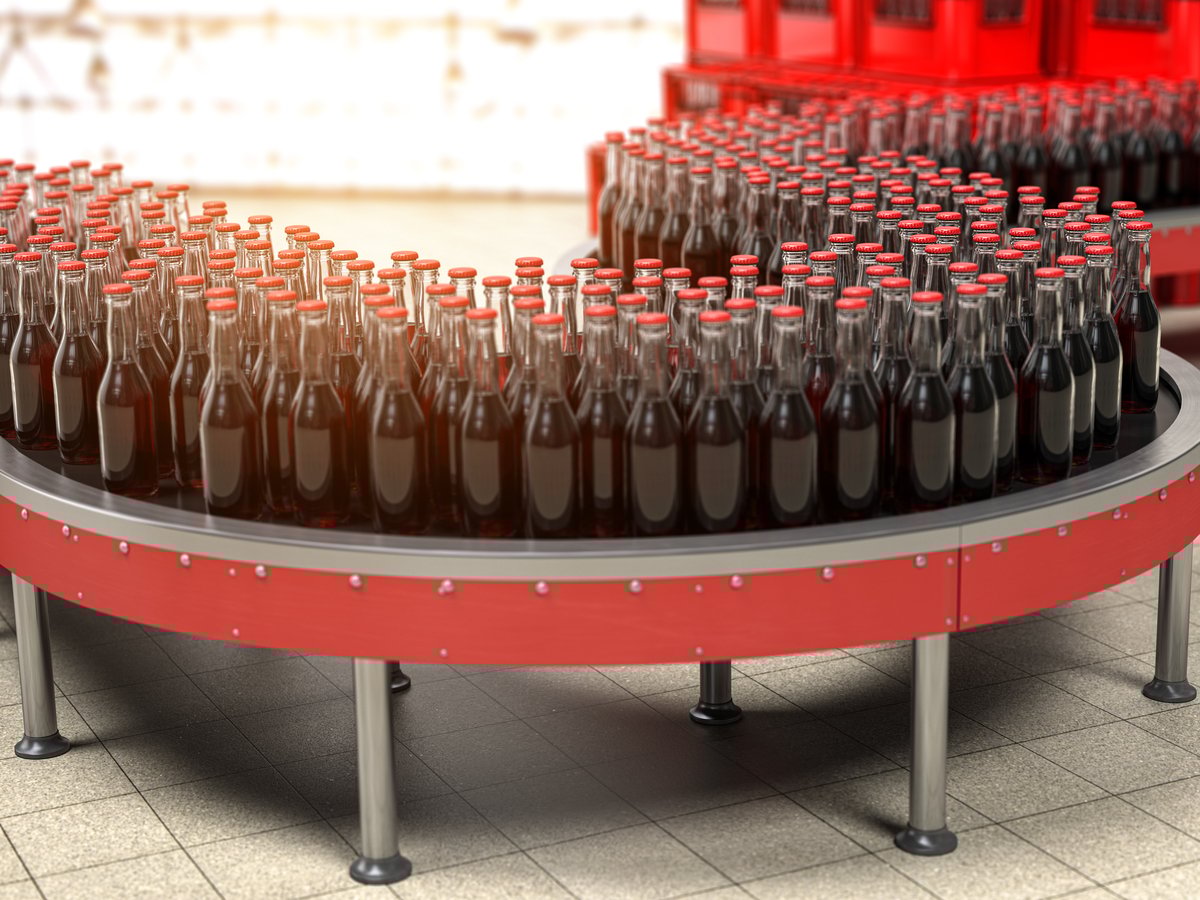 Bottles of soda moving on a conveyor belt.