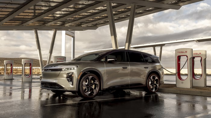 Lucid Gravity electric SUV plugged into a Tesla charger. 