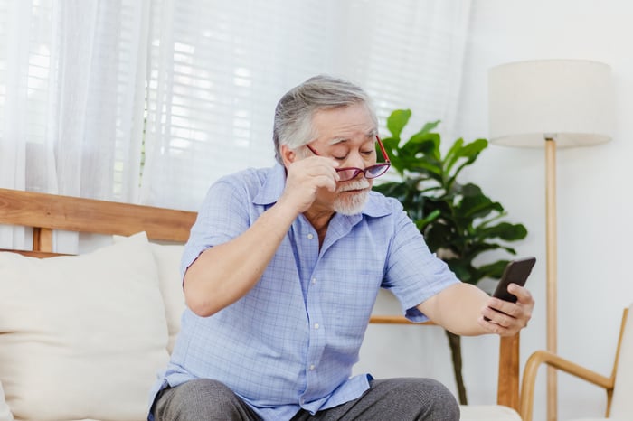 A person squints at a smartphone.