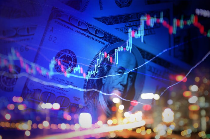 A chart line moving up over a city backdrop and hundred-dollar bills.
